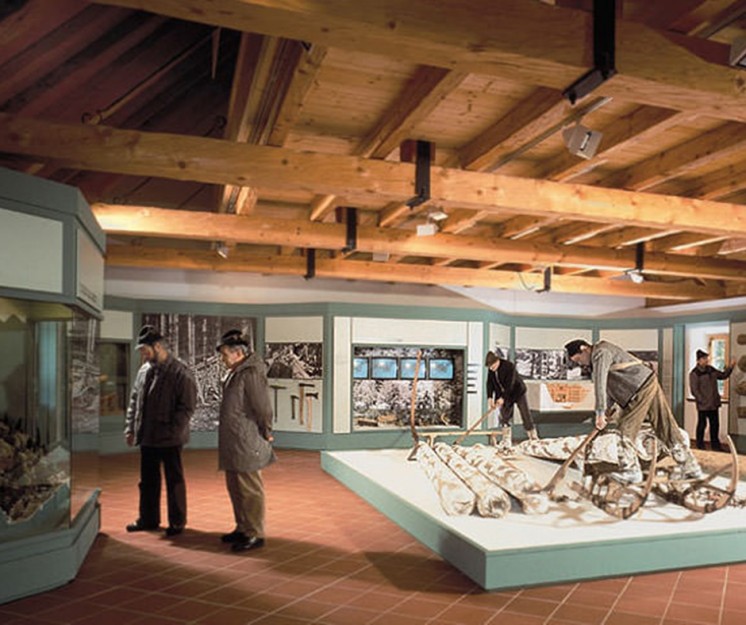 Blick in die großen Halle des Holzknechtmuseums, in der mehrere arbeitende Figuren stehen